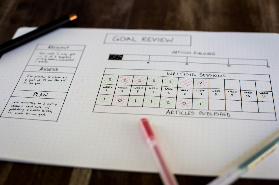 person writing financial goals on paper